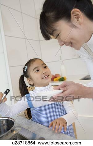 Picture - Girl helping to cook. Fotosearch