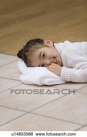 Stock Photo - Girl lying down and put her face on the towel. Fotosearch