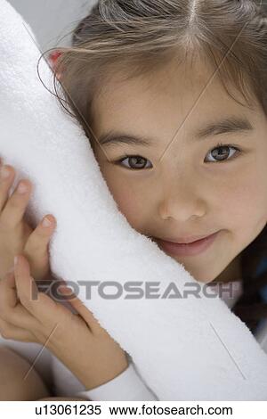 Stock Photography - Girl put her face on the clean towel. Fotosearch