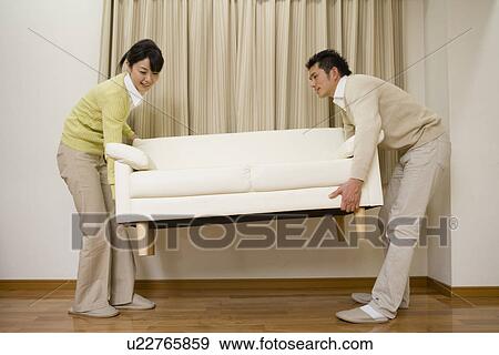Husband and wife are carrying a sofa View Large Photo Image Stock Photo - Husband and wife are carrying a sofa. Fotosearch