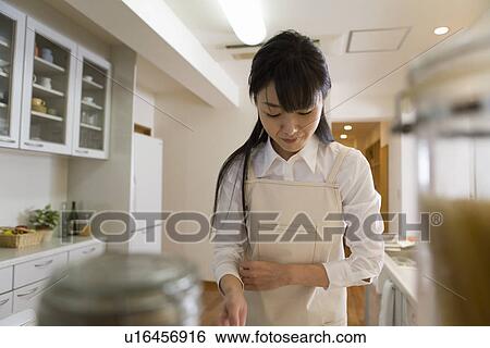 Mid Adult Woman cooking in the kitchen View Large Photo Image Stock Photograph - Mid Adult Woman cooking in the kitchen. Fotosearch