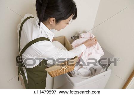 Stock Photo - Mid Adult Woman do the laundry. Fotosearch
