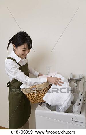 Stock Photo - Mid Adult Woman do the laundry. Fotosearch