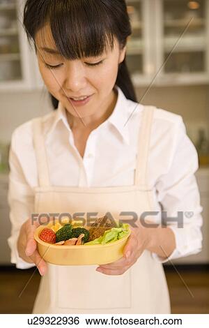 Mid Adult Woman looking at lunch box View Large Photo Image Stock Photograph - Mid Adult Woman looking at lunch box. Fotosearch
