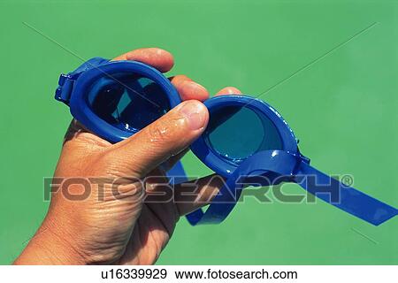 Stock Photo - Closed Up Image of Water Goggles in a Hand, Front View. Fotosearch