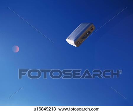 Stock Image - Business case flying in the air, Low Angle View, Lens Flare, Copy Space. Fotosearch