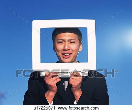 Stock Image - Businessman Holding Frame, Front View. Fotosearch