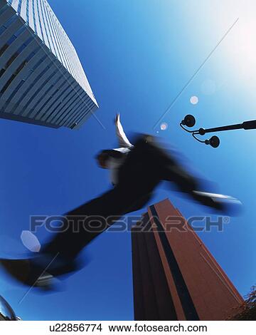 Businessman Jumping, Low Angle View, Lens Flare, Long Exposure View Large Photo Image Picture - Businessman Jumping, Low Angle View, Lens Flare, Long Exposure. Fotosearch