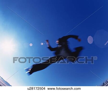 Businessman Jumping, Low Angle View, Lens Flare, Long Exposure, Copy Space View Large Photo Image Picture - Businessman Jumping, Low Angle View, Lens Flare, Long Exposure, Copy Space. Fotosearch