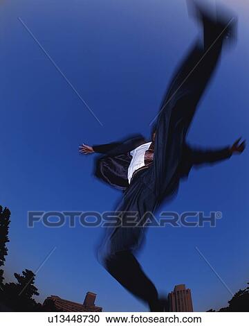 Stock Image - Businessman Jumping, Low Angle View, Long Exposure, Copy Space. Fotosearch