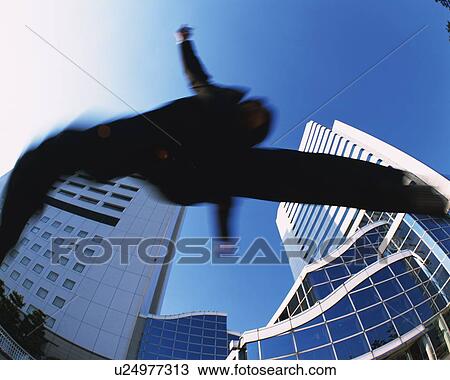 Stock Image - Businessman Jumping, Low Angle View, Long Exposure, Fish Eye. Fotosearch