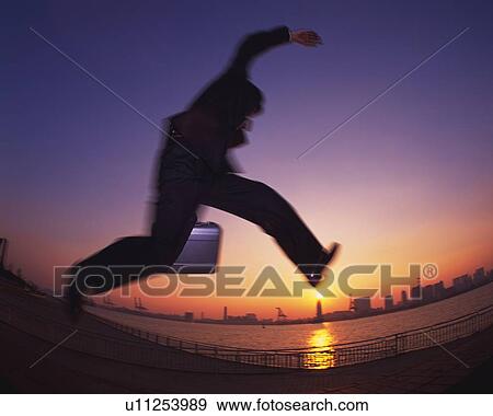 Businessman Jumping, Low Angle View, Long Exposure, Fish Eye View Large Photo Image Stock Photo - Businessman Jumping, Low Angle View, Long Exposure, Fish Eye. Fotosearch