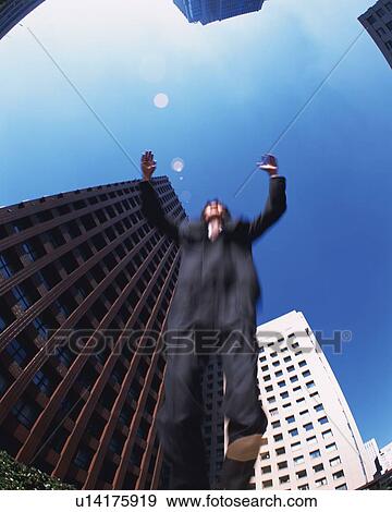 Stock Photo - Businessman Jumping, Low Angle View, Lens Flare, Long Exposure, Fish Eye. Fotosearch