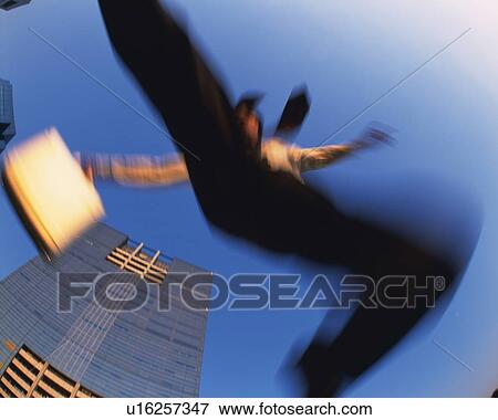 Stock Photo - Businessman Jumping, Low Angle View, Long Exposure. Fotosearch