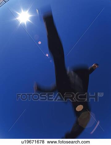 Stock Photo - Businessman Jumping, Low Angle View, Lens Flare, Long Exposure. Fotosearch