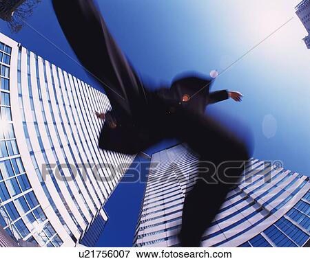 Businessman Jumping, Low Angle View, Lens Flare, Long Exposure, Fish Eye View Large Photo Image Stock Photo - Businessman Jumping, Low Angle View, Lens Flare, Long Exposure, Fish Eye. Fotosearch