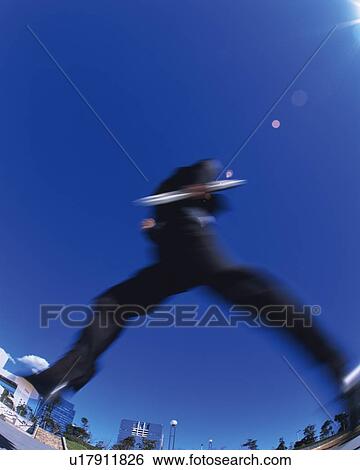 Stock Photograph - Businessman Jumping, Low Angle View, Lens Flare, Long Exposure, Copy Space. Fotosearch