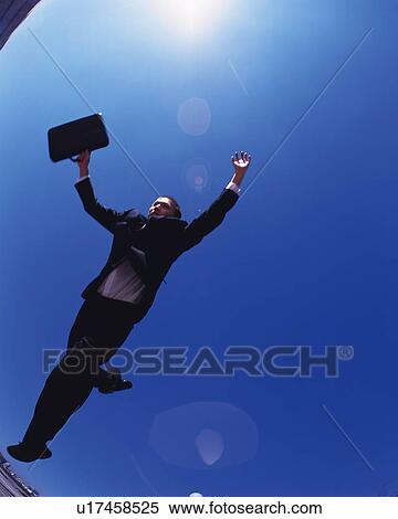 Businessman Jumping, Low Angle View, Lens Flare View Large Photo Image Stock Photography - Businessman Jumping, Low Angle View, Lens Flare. Fotosearch