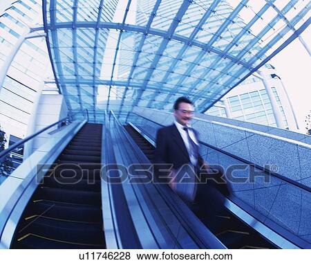 Businessman on Escalator, Low Angle View, Long Exposure View Large Photo Image Stock Photo - Businessman on Escalator, Low Angle View, Long Exposure. Fotosearch