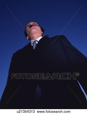 Stock Image - Businessman with Headset, Low Angle View. Fotosearch