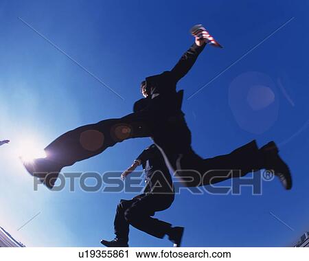 Two Businessmen Jumping, Low Angle View, Lens Flare, Long Exposure View Large Photo Image Stock Image - Two Businessmen Jumping, Low Angle View, Lens Flare, Long Exposure. Fotosearch