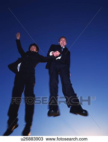 Two Businessmen Jumping, Low Angle View, Long Exposure View Large Photo Image Stock Image - Two Businessmen Jumping, Low Angle View, Long Exposure. Fotosearch