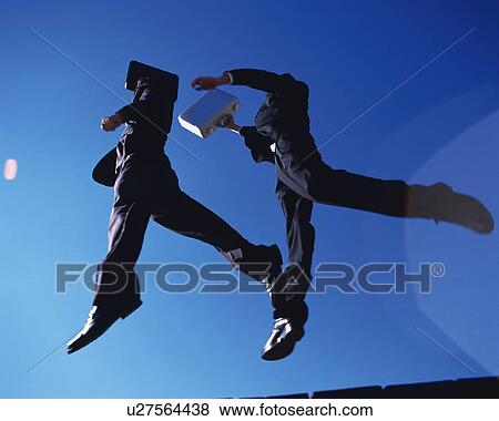 Two Businessmen Jumping, Low Angle View, Lens Flare View Large Photo Image Stock Photo - Two Businessmen Jumping, Low Angle View, Lens Flare. Fotosearch