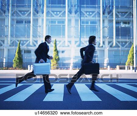 Stock Image - Two Businessmen Running, Side View. Fotosearch