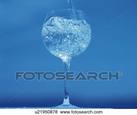 Stock Photo - Pouring Water in a Wine Glass, Low Angle View, Close Up, Toned Image,. Fotosearch