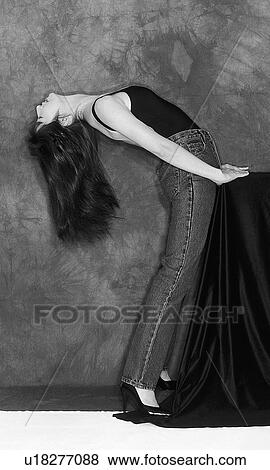 Stock Photo - Portrait of a woman bending over backwards, black and white, side view. Fotosearch