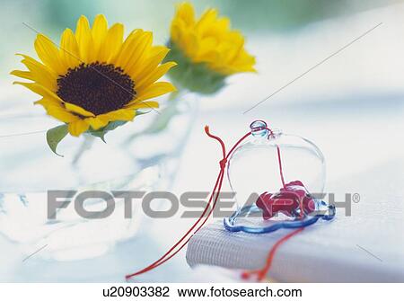 Stock Image - Japanese Wind Bell and Sunflower, Close Up, Side View, Differential Focus, In Focus, Out Focus. Fotosearch