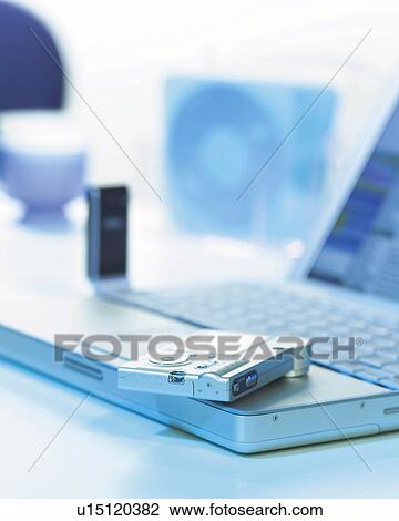 Stock Image - Notebook Computer and Digital Camera, Close Up, Differential Focus, In Focus, Out Focus, Toned Image. Fotosearch