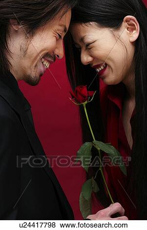 Stock Photo - Man in Black and Woman in Red, Side View. Fotosearch