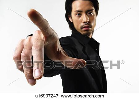 Stock Photo - Young Man in Black Pointing At, Front View. Fotosearch