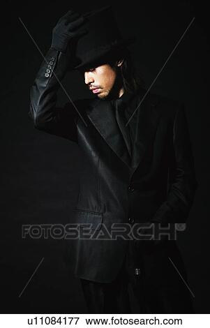 Stock Photo - Young Man in Black with Hat and Stick, Front View. Fotosearch