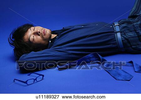 Stock Photo - Young Man in Blue Sleeping, Side View. Fotosearch
