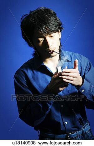 Young Man in Blue Smoking, High Angle View View Large Photo Image Stock Photo - Young Man in Blue Smoking, High Angle View. Fotosearch