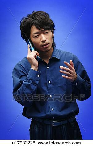 Young Man in Blue Talking on Phone, Front View View Large Photo Image Stock Photo - Young Man in Blue Talking on Phone, Front View. Fotosearch