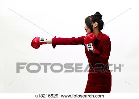 Stock Photo - Young Woman in Red Punching, Side View. Fotosearch