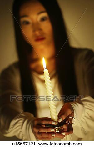 Stock Image - Young Woman in White Holding A Candle, Front View, Differential Focus. Fotosearch