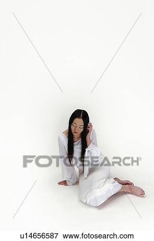 Stock Photo - Young Woman in White Sitting Down, High Angle View, Copy Space. Fotosearch