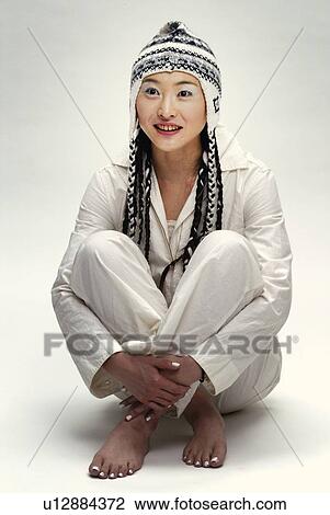 Stock Image - Young Woman in White Sitting Down, Front View. Fotosearch