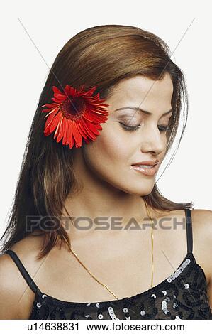 Stock Image - Close-up of a young woman wearing a flower. Fotosearch