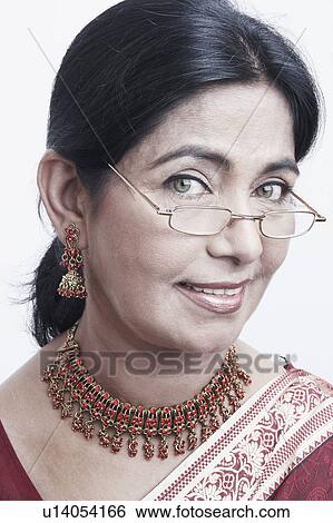 Stock Photograph - Portrait of a mature woman peeking over an eyeglasses. Fotosearch