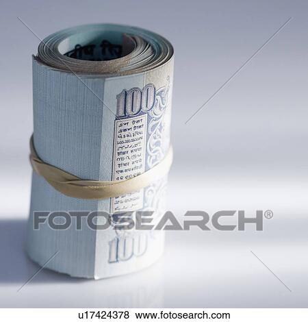 Close-up of a rolled up bundle of Indian one hundred rupee banknotes bound with a rubber band View Large Photo Image Stock Photo - Close-up of a rolled up bundle of Indian one hundred rupee banknotes bound with a rubber band. Fotosearch