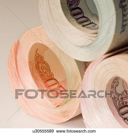 Stock Photo - Close-up of a stack of rolled up Indian banknotes. Fotosearch