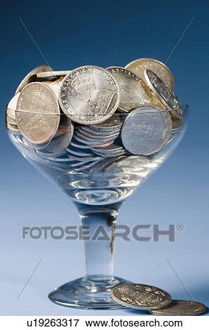 Stock Photo - Close-up of Indian silver coins in a stem glass. Fotosearch