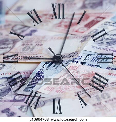 Stock Photo - High angle view of a clock on Indian banknotes. Fotosearch