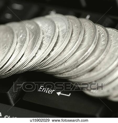Stock Photo - High angle view of antique Indian one rupee coins on a computer keyboard. Fotosearch