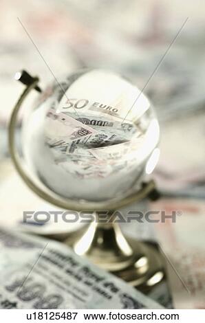 Stock Photo - High angle view of Euro and Indian banknotes in a glass globe. Fotosearch